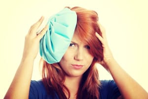 Red Haired Woman Uses Hot Compress to Relieve TMJ Pain in Temple